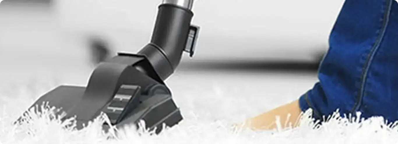 Close-up of a professional vacuuming a white carpet in Ansonia.